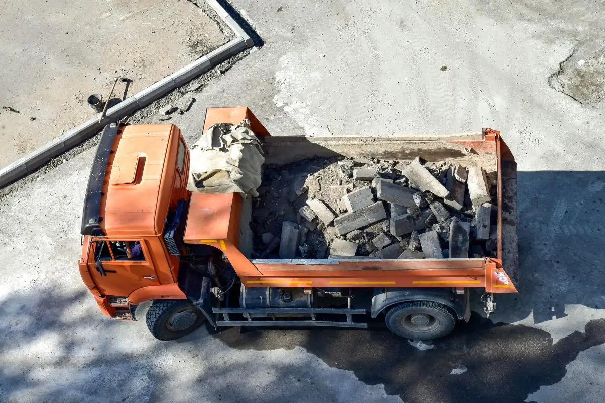 Heavy dump truck loaded with construction debris at a city worksite, representing potential construction accident or roadway hazard.