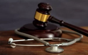Judge’s gavel and stethoscope on a wooden desk symbolizing medical malpractice and personal injury law.